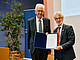 Rektor Prof. Dr. Christoph Schneider überreicht die "Gasthörerschaft auf Lebenszeit" an den Hohenheimer Alumnus und ehemaligen Ministerpräsidenten von Baden-Württemberg Winfried Kretschmann. Die Gasthörerschaft gilt ihm und seiner Frau Gerlinde Kretschmann. | Universität Hohenheim/Florian Gerlach
